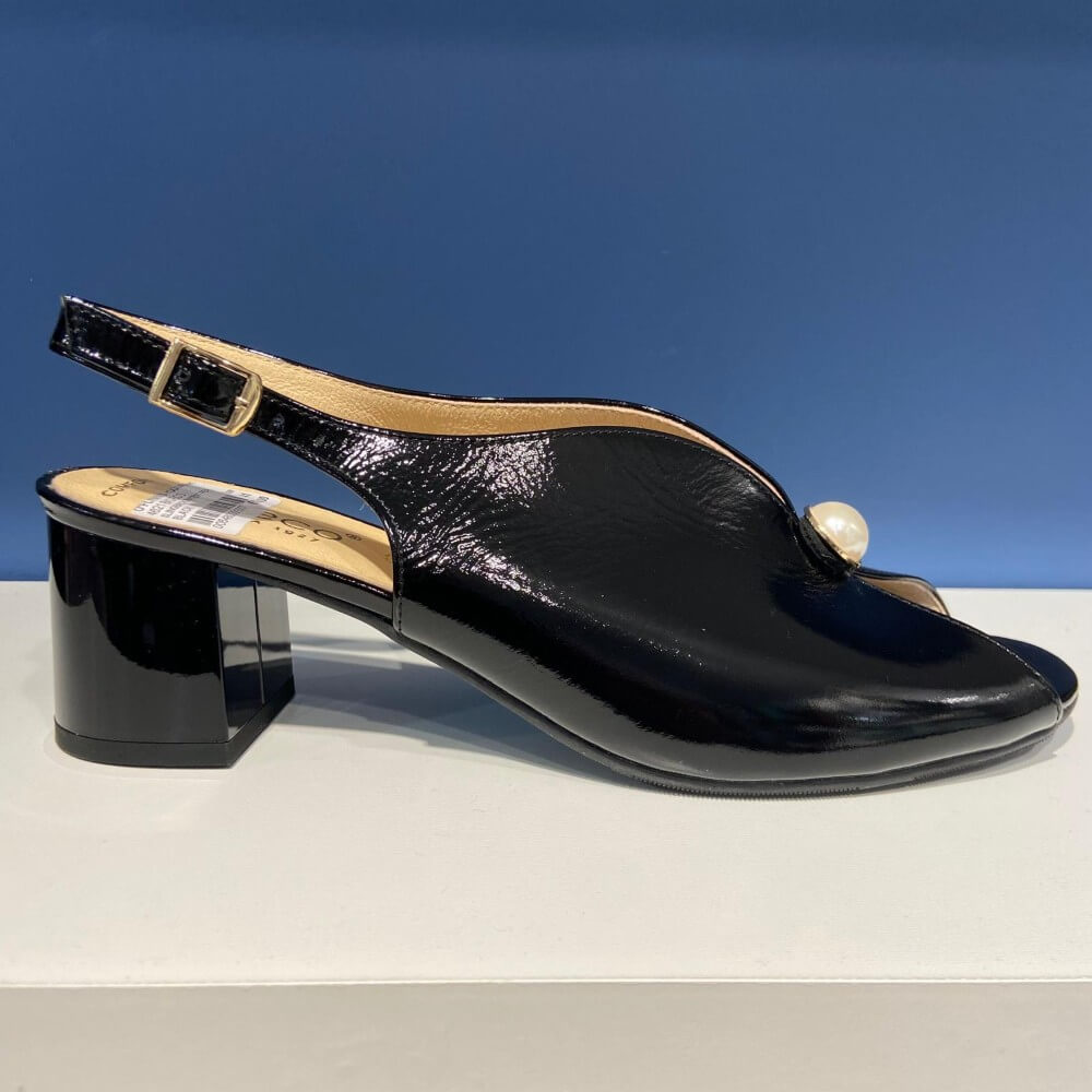 Bioeco Black sandal with a pearl accent on a white surface and blue background