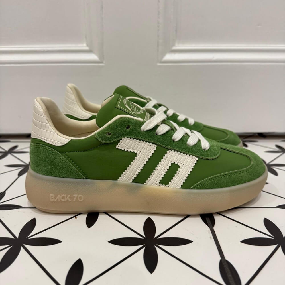 Back 70 Brooklyn Green sneakers with white laces on a black and white patterned floor.
