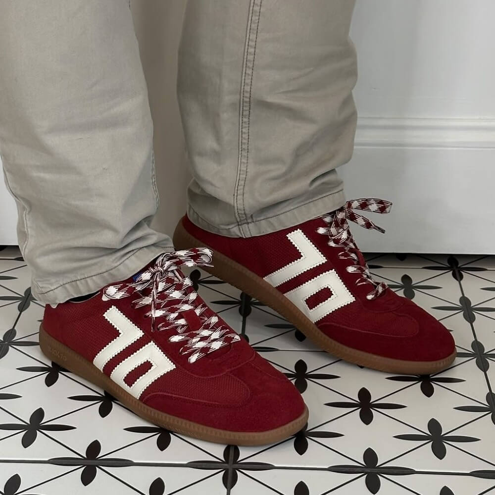 Back 70 Red sneakers with white accents worn on a patterned floor.