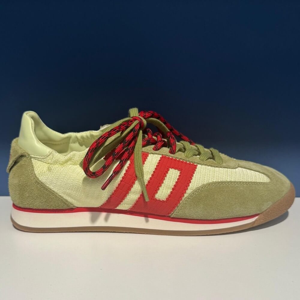 Back 70 Green and red sneaker with a white sole on a gradient background