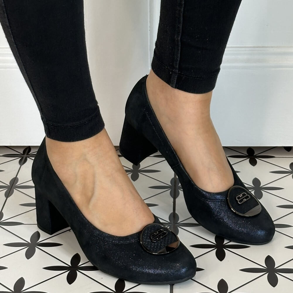 Navy Shimmer  high-heeled shoes worn with black pants on a patterned floor. Bioeco 6844 Block Heel Navy Shimmer Suede court shoes