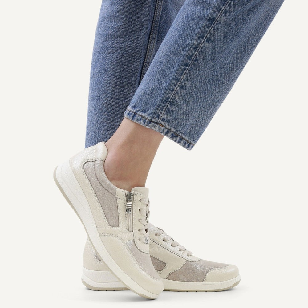 Caprice White sneakers worn with blue jeans on a white background