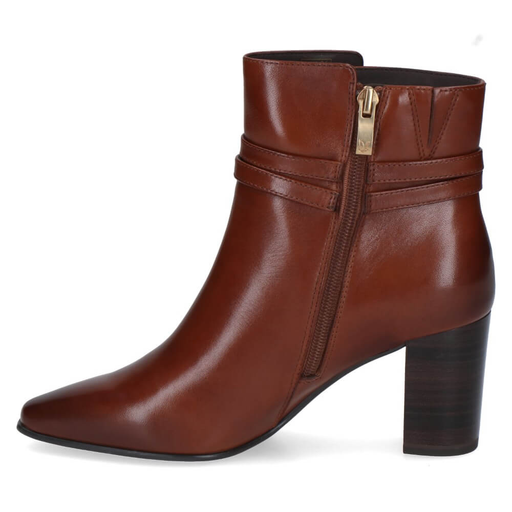 A Caprice dark brown leather ankle boot with a block heel, pointed toe, and a decorative strap with a gold-tone zip and  detail around the ankle.