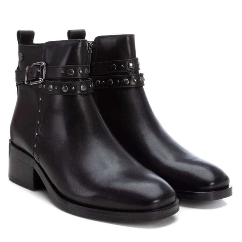 Pair of black leather ankle boots with studded details on a white background