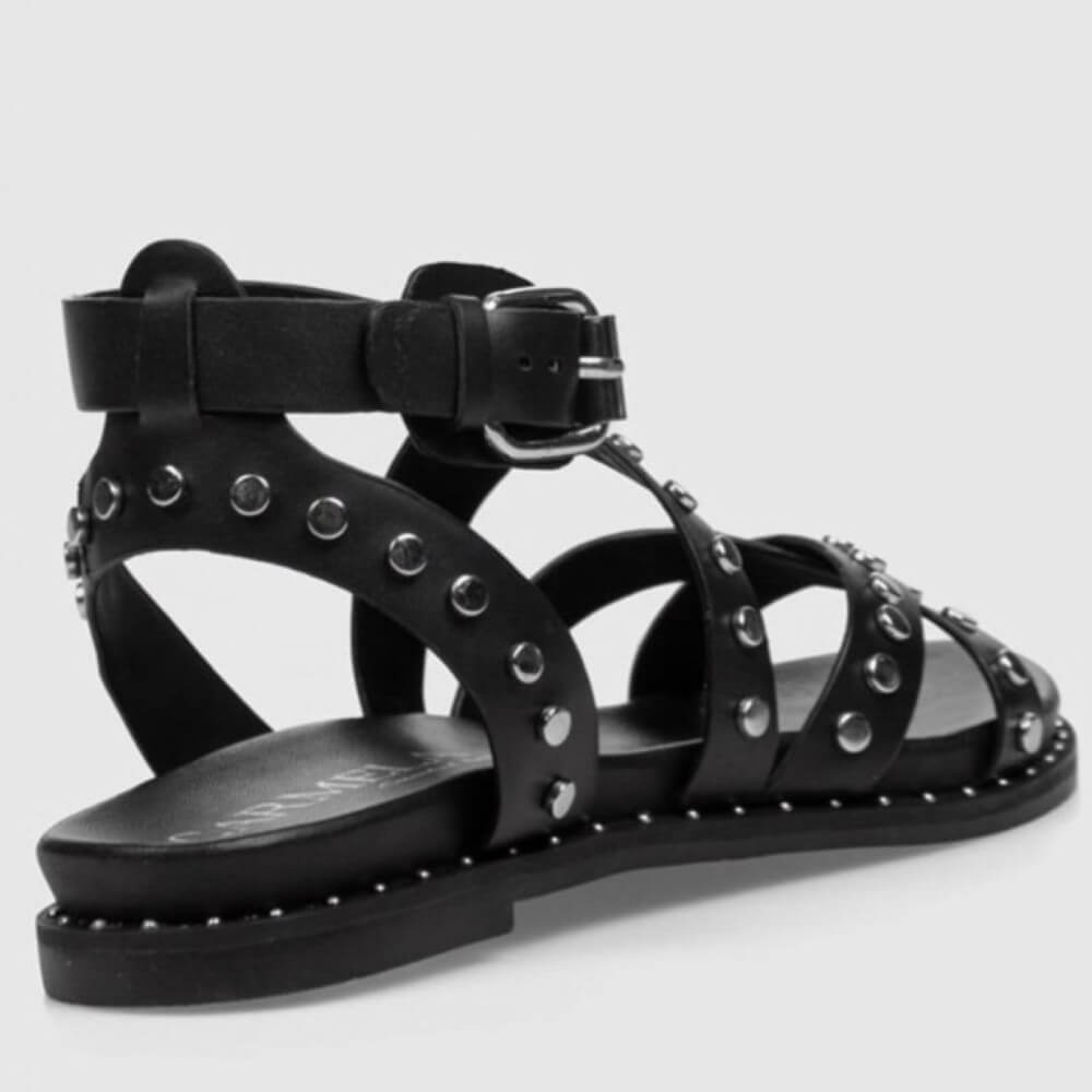 Carmela gladiator Black studded sandal on a light gray background