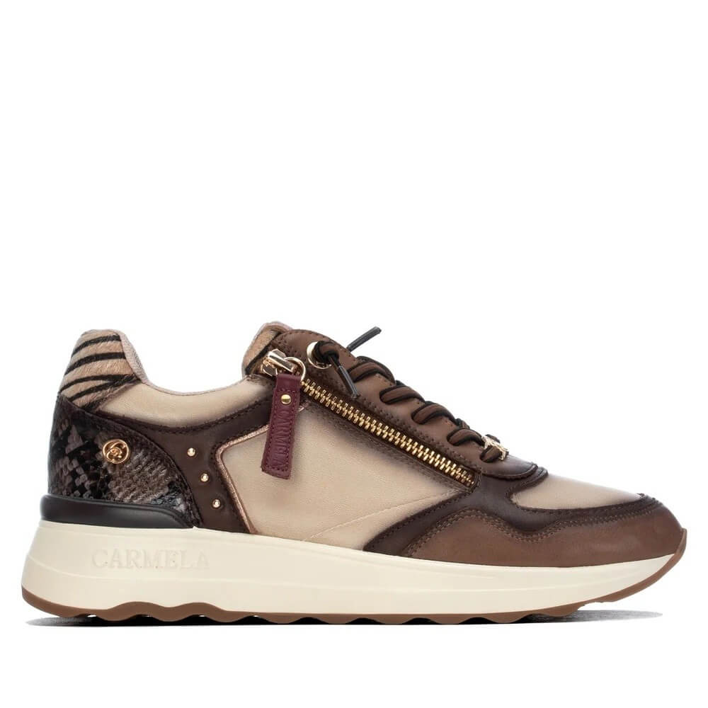 A low-top sneaker by Carmela, featuring a color-blocked design in brown and beige with snakeskin-patterned heel panel, gold zipper, and a thick cream-colored midsole.