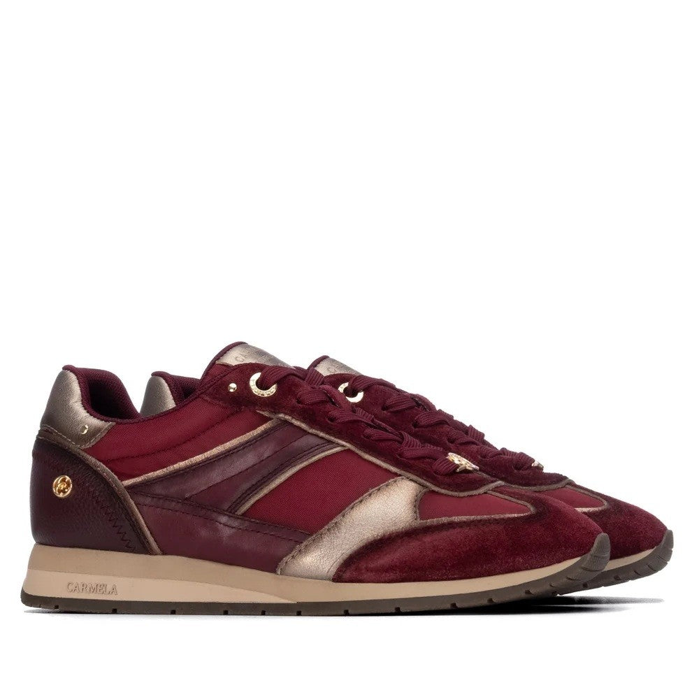 A pair of Carmela low-top sneakers in burgundy and metallic gold leather with a beige midsole, shown in a side profile on a white background. The brand name 'CARMELA' is visible on the side of the sole.