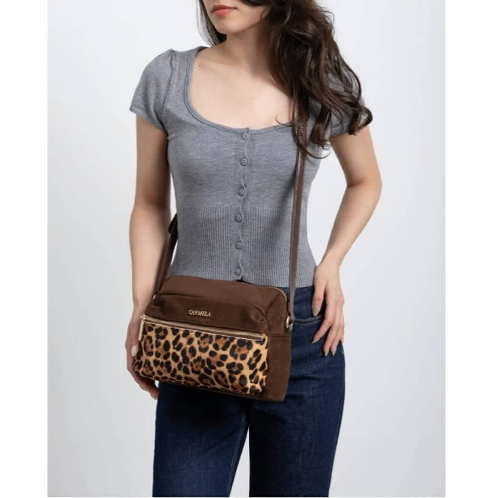 Woman holding a brown crossbody bag with leopard print accent on a white background Carmela Shoulder Bag 186186 Camel Leopard Print