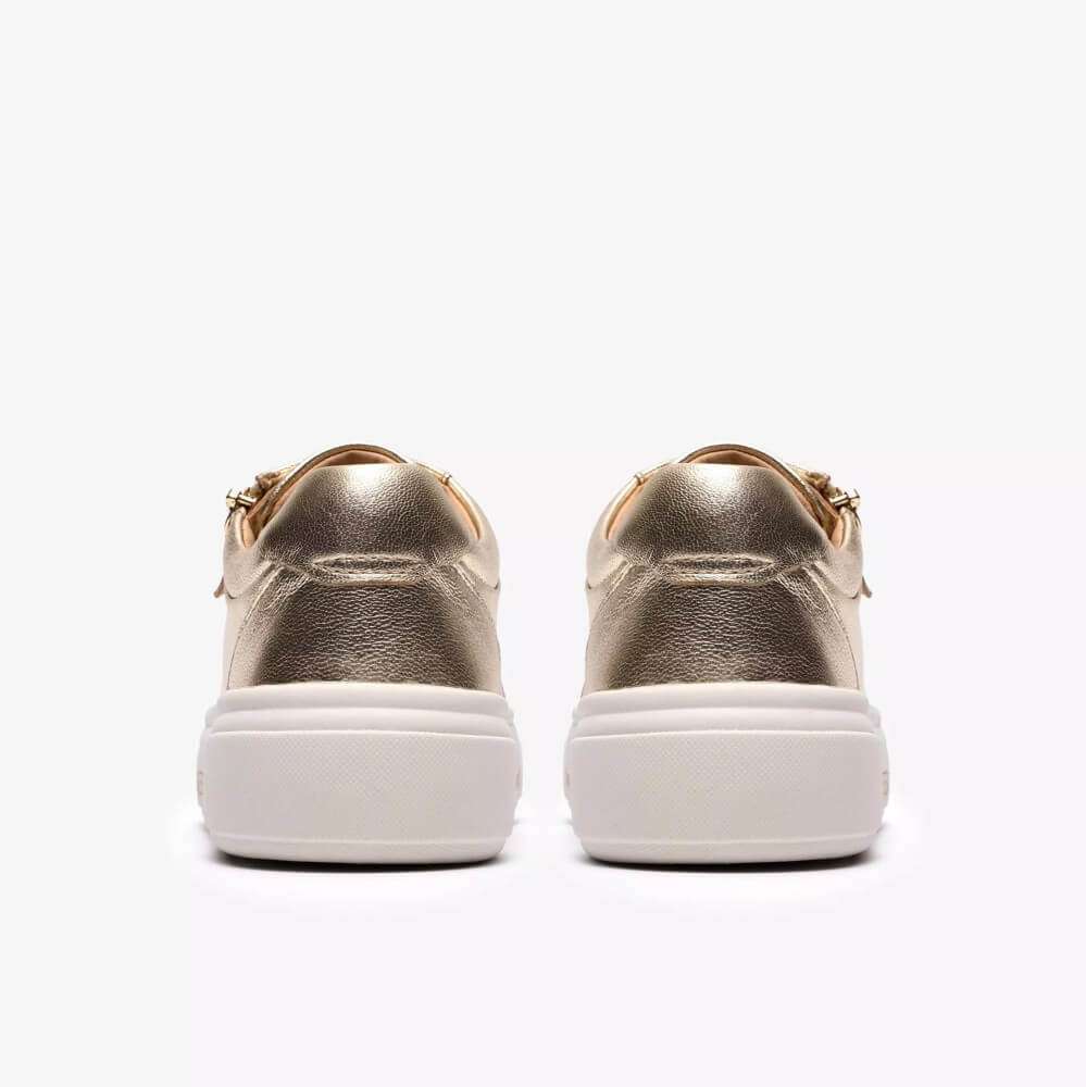 Clarks Gold sneakers with white soles on a white background