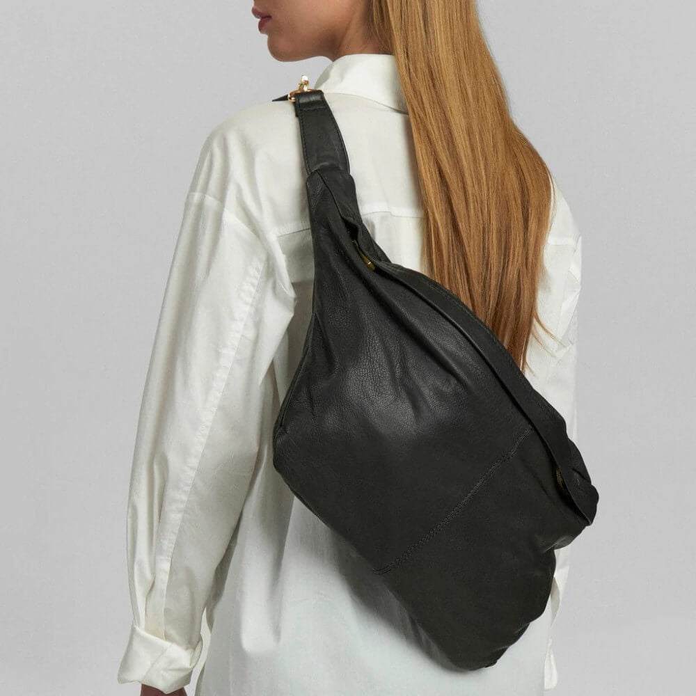 Person wearing a Depeche black shoulder bag on a plain background