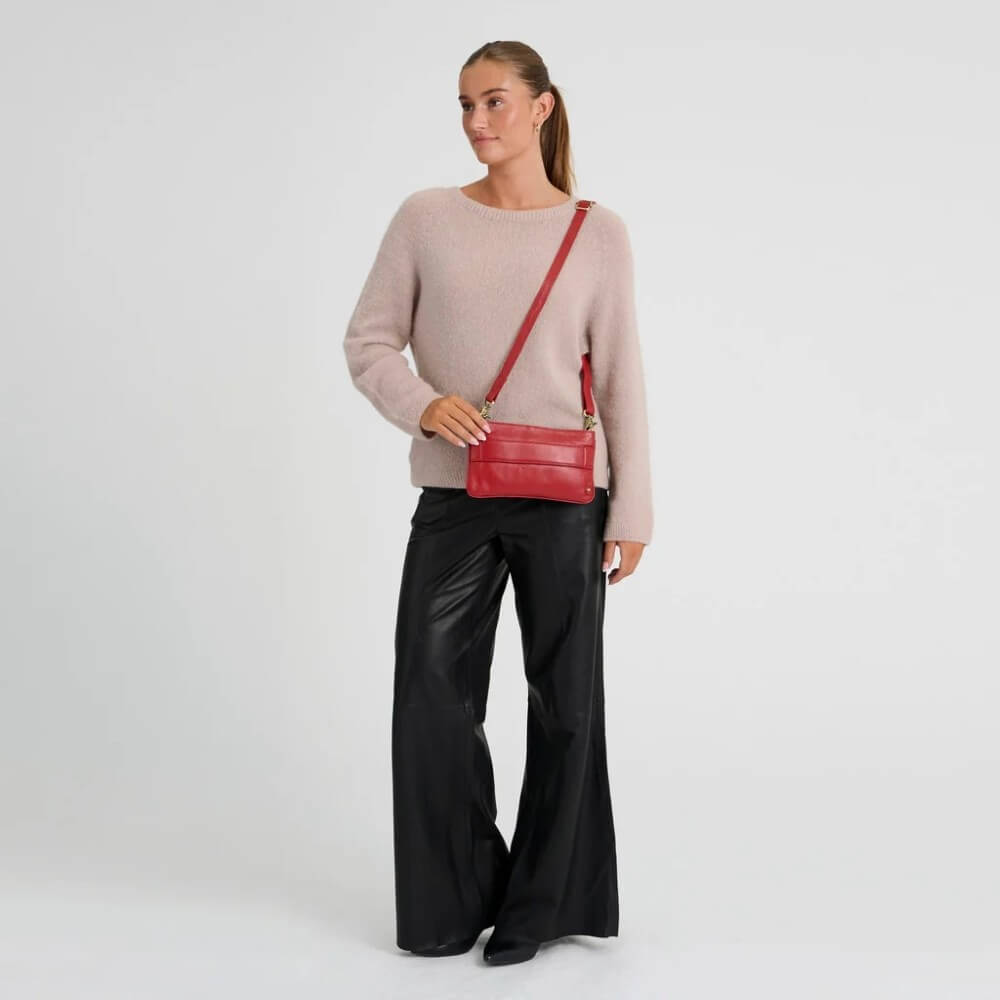 Person wearing a Depeche red leather crossbody
