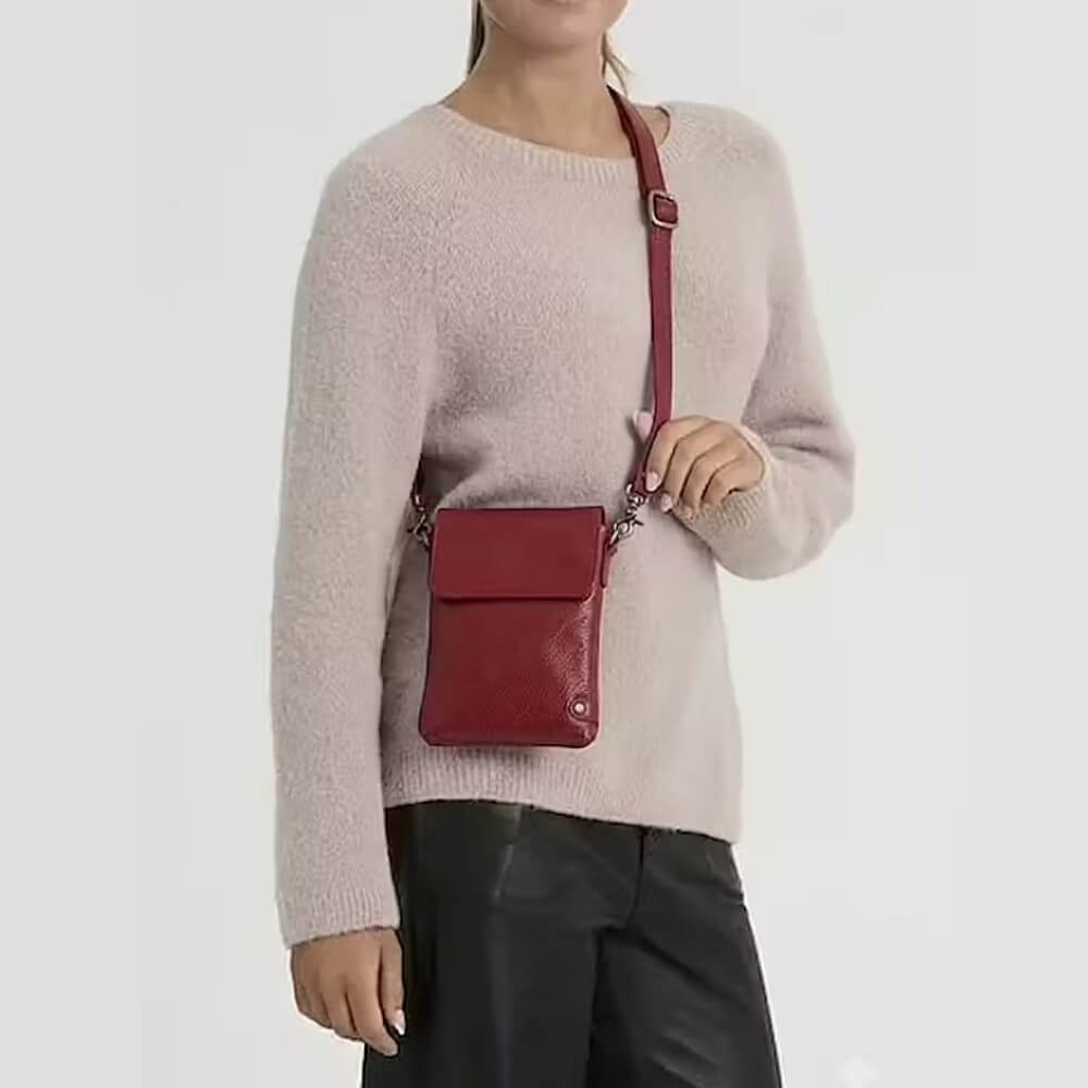 person wearing a cream jumper and a Depeche Red crossbody bag