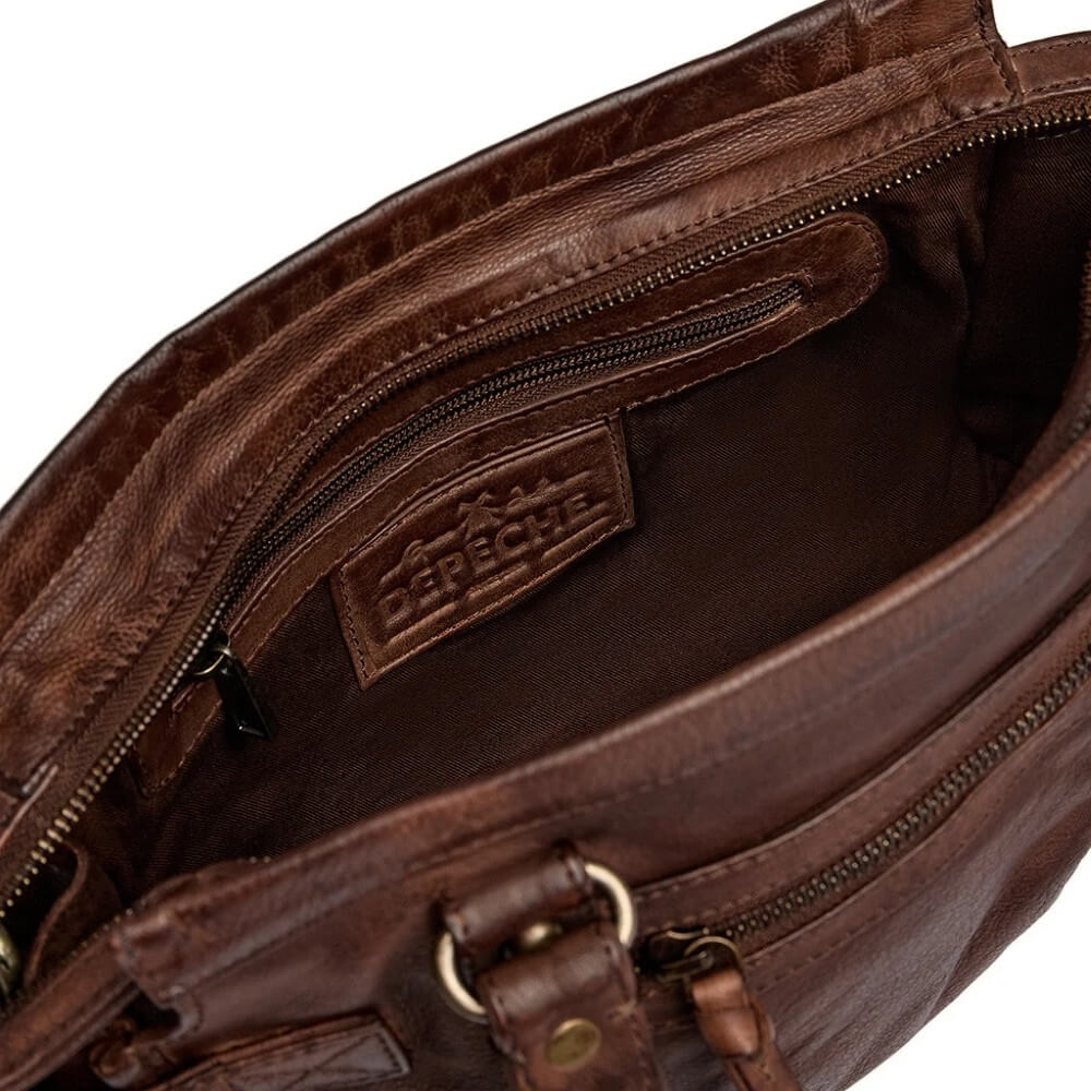 Close-up of the interior of a brown leather bag, showing a zippered pocket with a brand label that reads 'Depeche'.