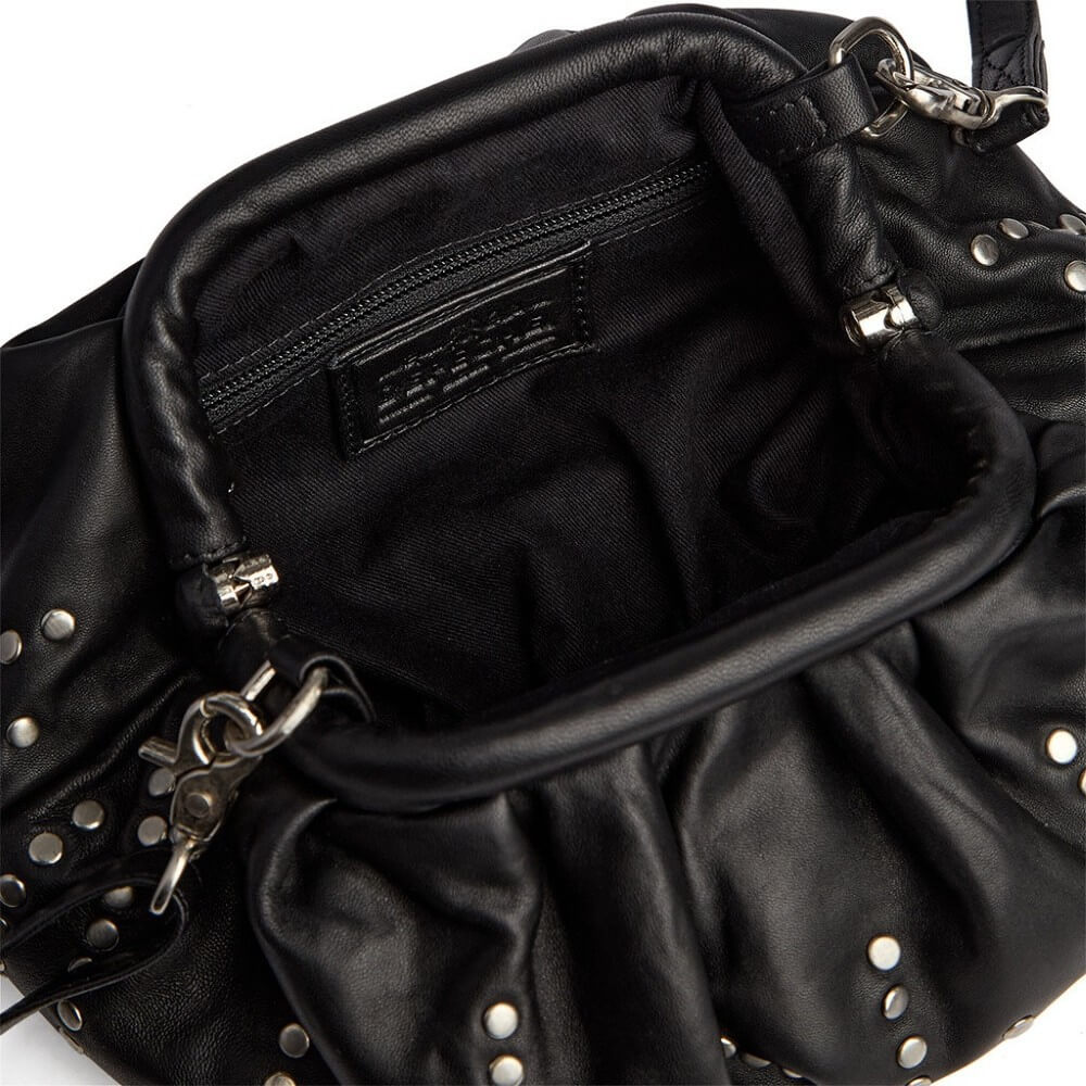 Close-up of a black leather shoulder bag showing the interior, studded edges, silver-tone hardware, and a black fabric lining with a visible Depeche logo patch.