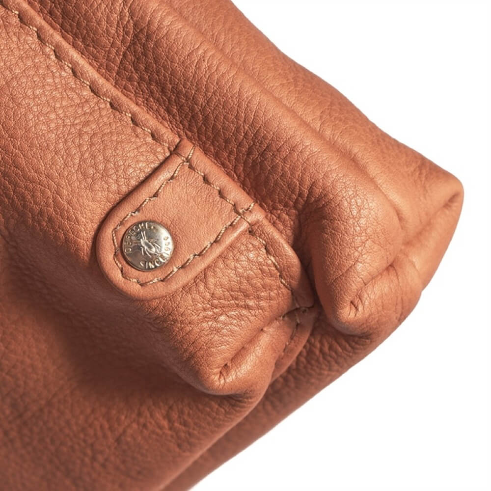 Close-up of a brown leather product with a brand logo on a white background
