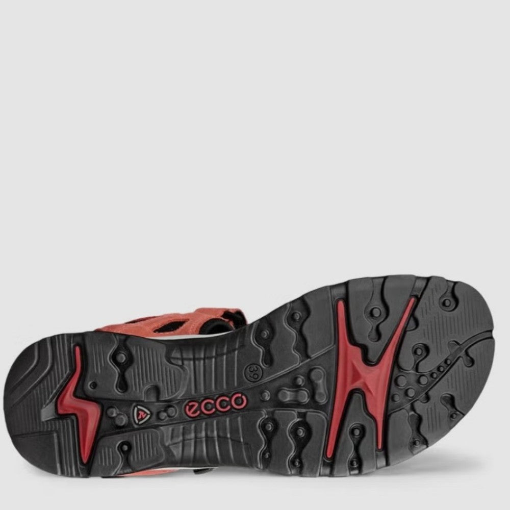 Close-up of a shoe sole with red and black design on a light gray background