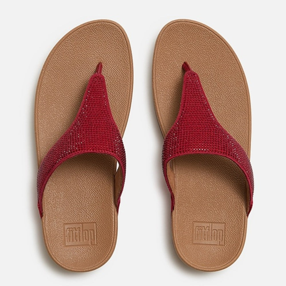 Pair of Fitflop red flip-flops with brown soles on a white background