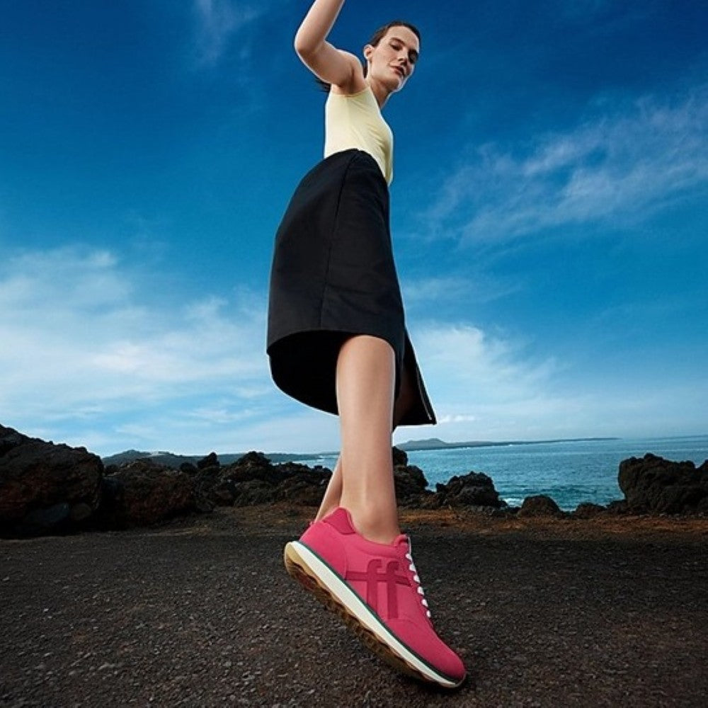 Person on a beach wearing Red Fitflop Trainers 