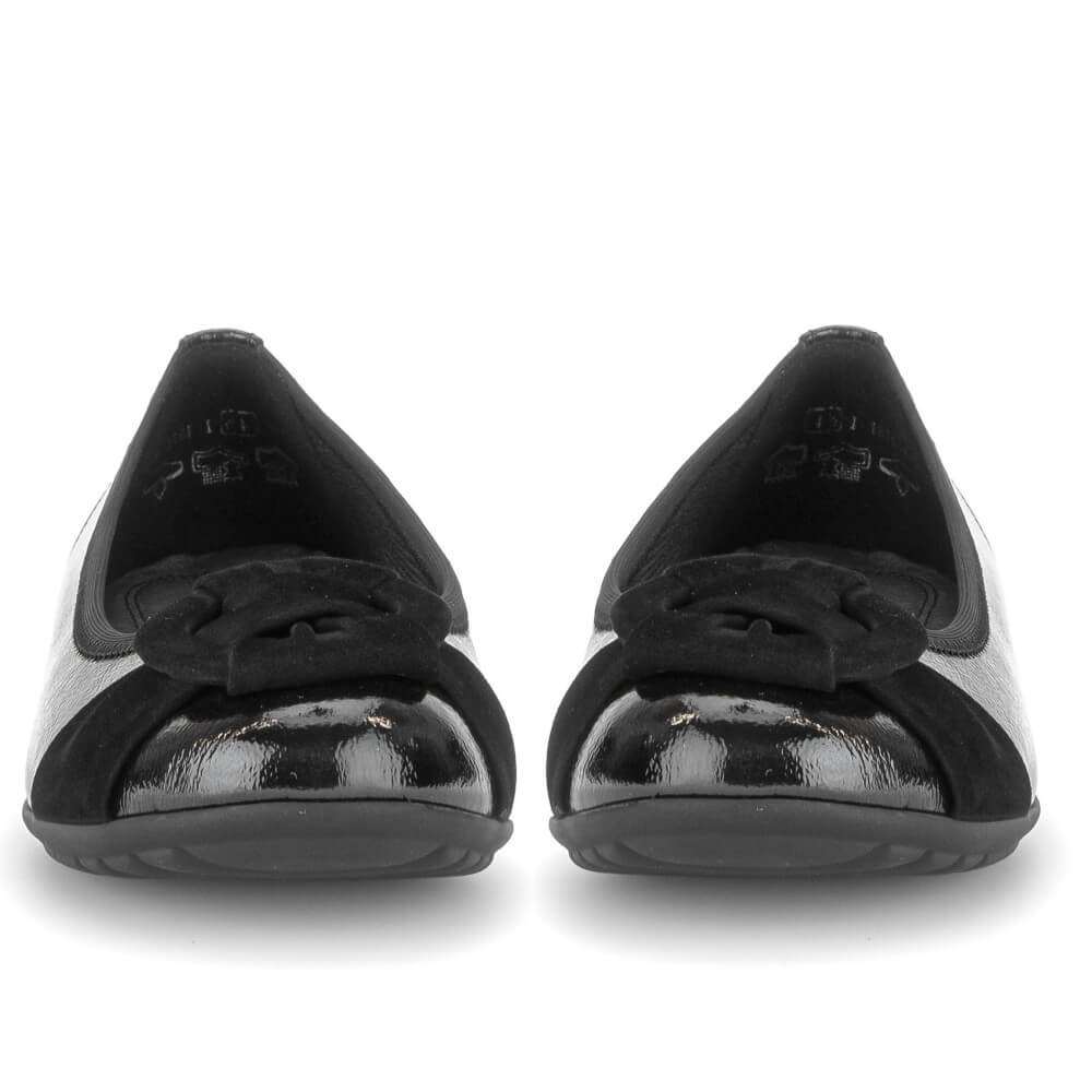 A pair of Gabor black ballet flats with a glossy patent leather toe cap and a black fabric bow detail across the vamp, shown from the front on a white background.