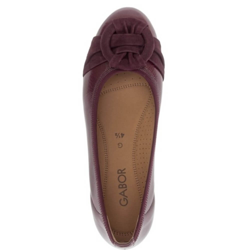 Gabor flat shoe in a deep burgundy leather, featuring a decorative knotted suede detail on the toe box and a low, flexible sole, shown against a plain white background.