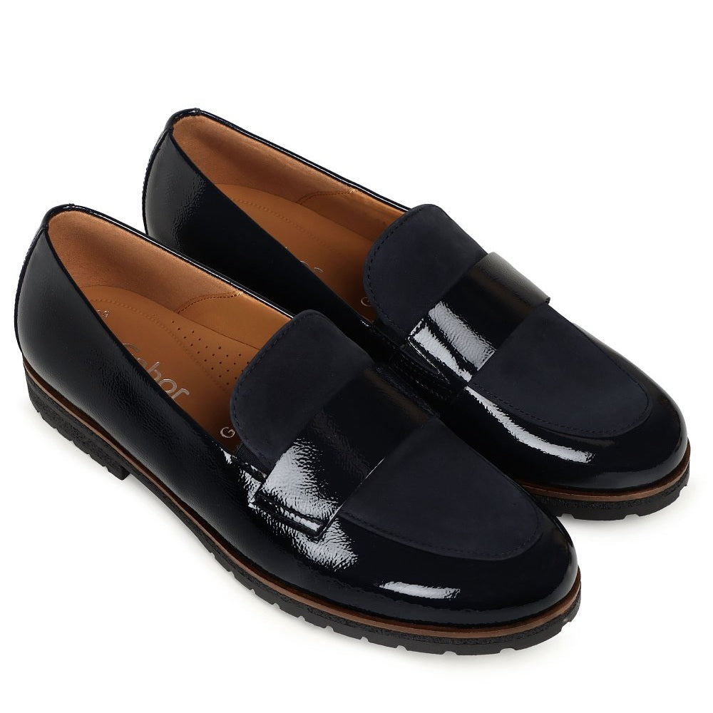 A pair of Gabor women's navy patent leather penny loafers with a brown contoured sole, displayed on a clean white background.