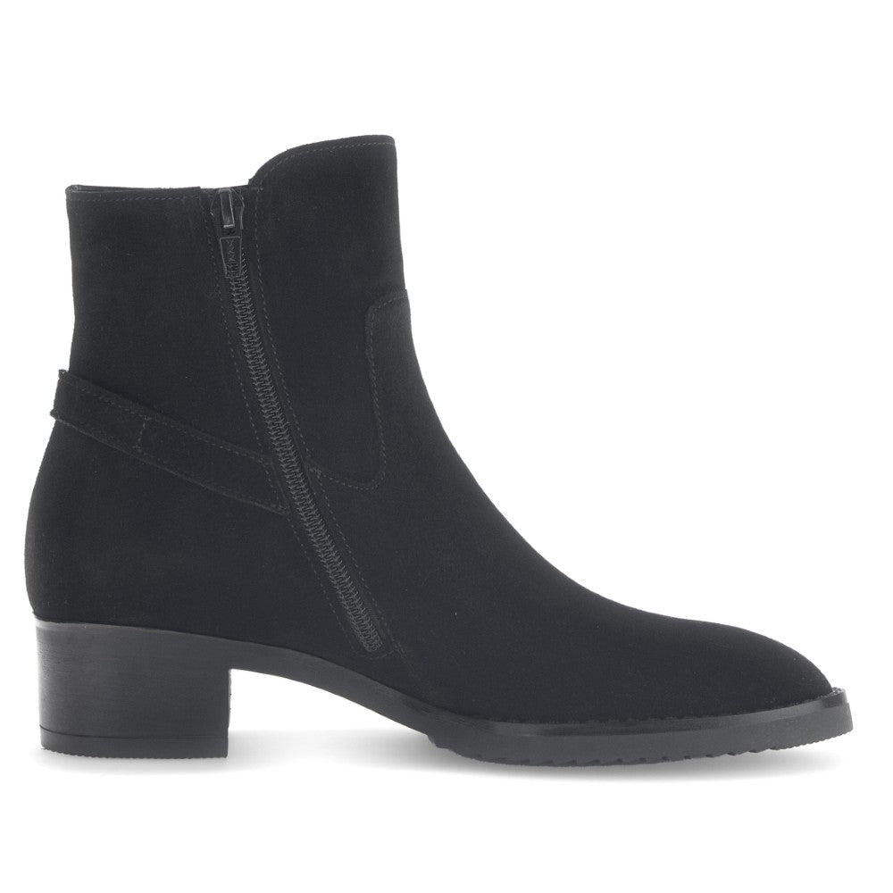 Black ankle boot with a strap on a white background