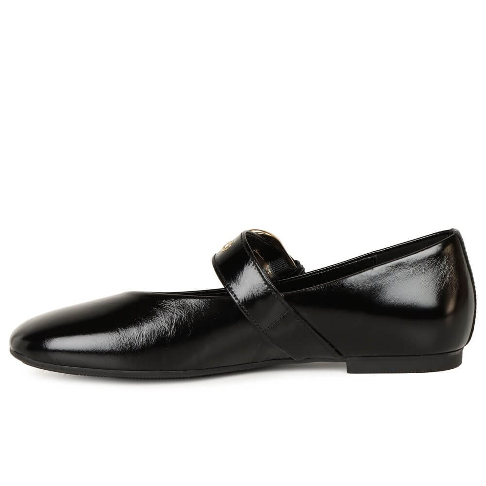 Black flat shoe with a strap on a white background