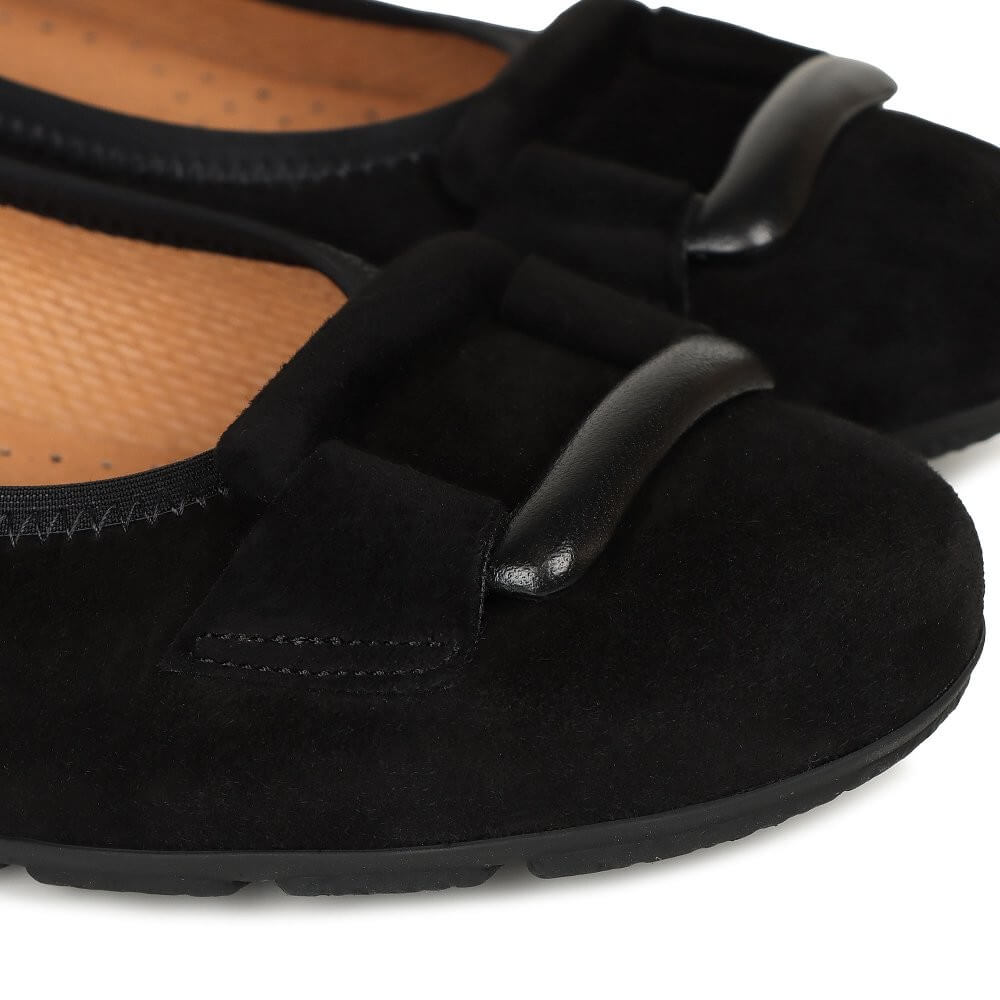 Black suede shoes with a buckle on a white background