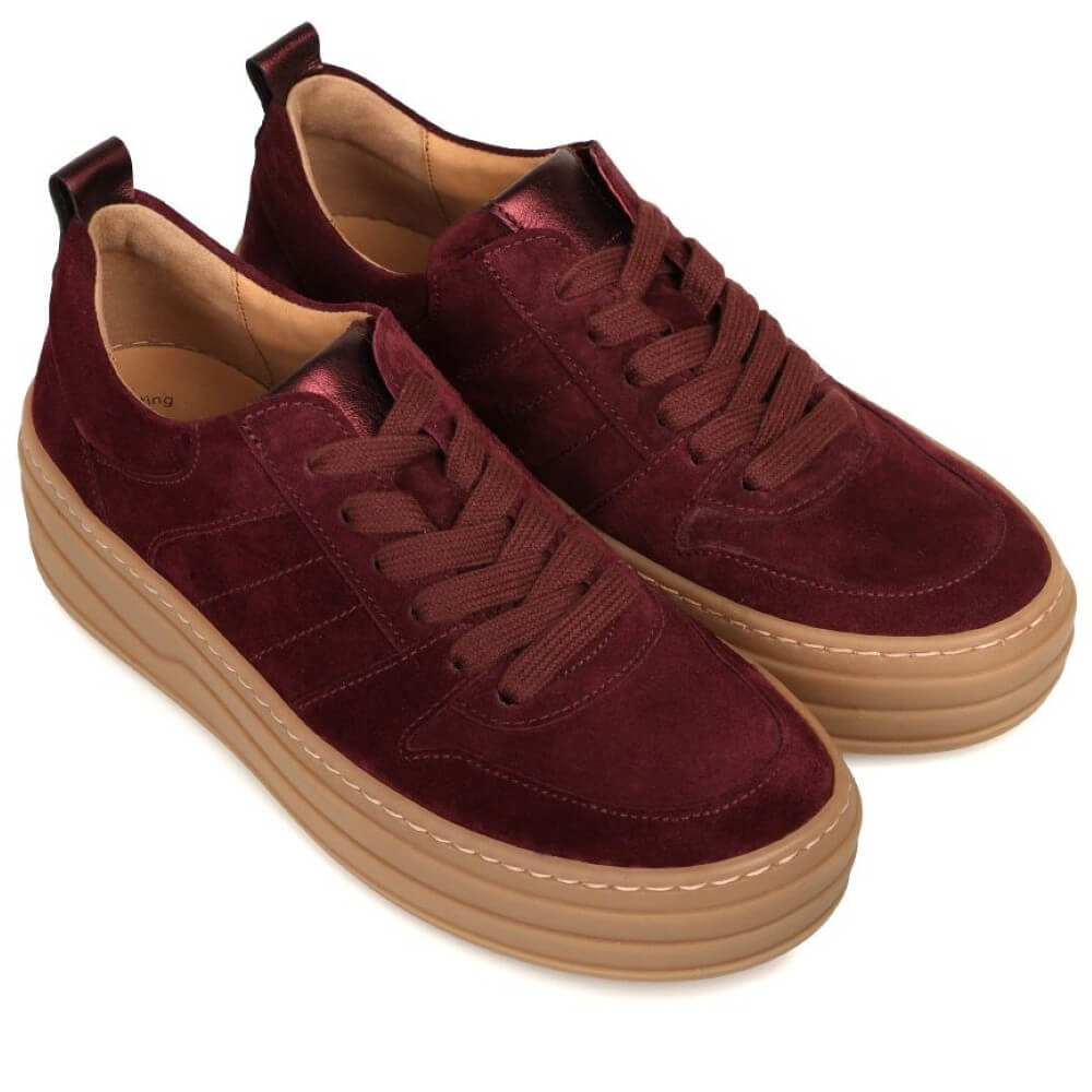 Maroon sneakers with brown soles on a white background