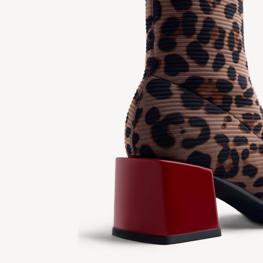 Close-up of Gioseppo a leopard-print ankle boot with a glossy red block heel on a white background.