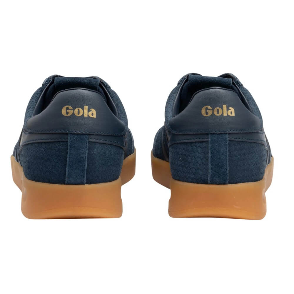 A pair of Gola brand sneakers shown from the back, featuring a navy blue suede and fabric upper with a gum rubber sole and gold 'Gola' branding on the heel.