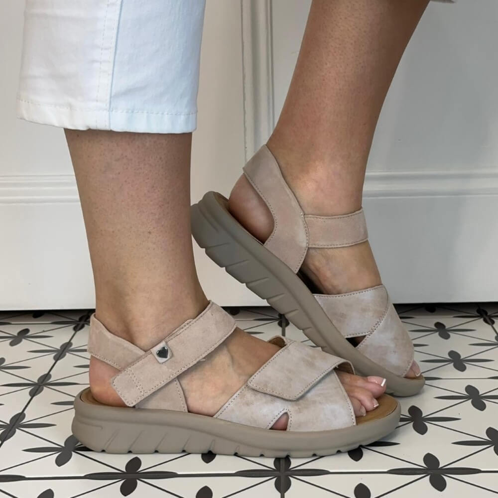 Hartjes Wide K Fit Beige sandals worn on a patterned floor with white pants.