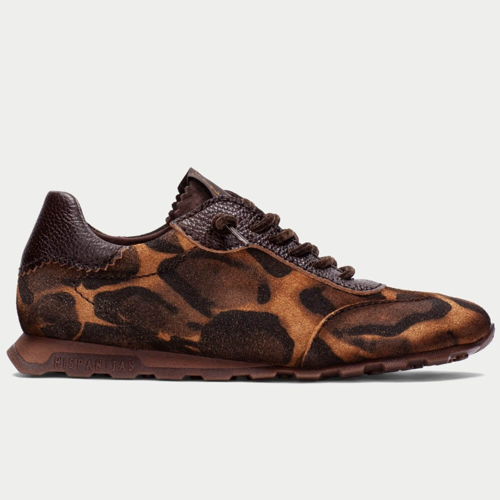 A Hispanitas  single brown sneaker with an abstract leopard-like pattern in shades of brown, black, and tan, shown in a side profile against a light gray background.