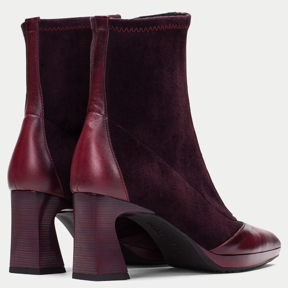 Pair of maroon high-heeled ankle boots on a light gray background