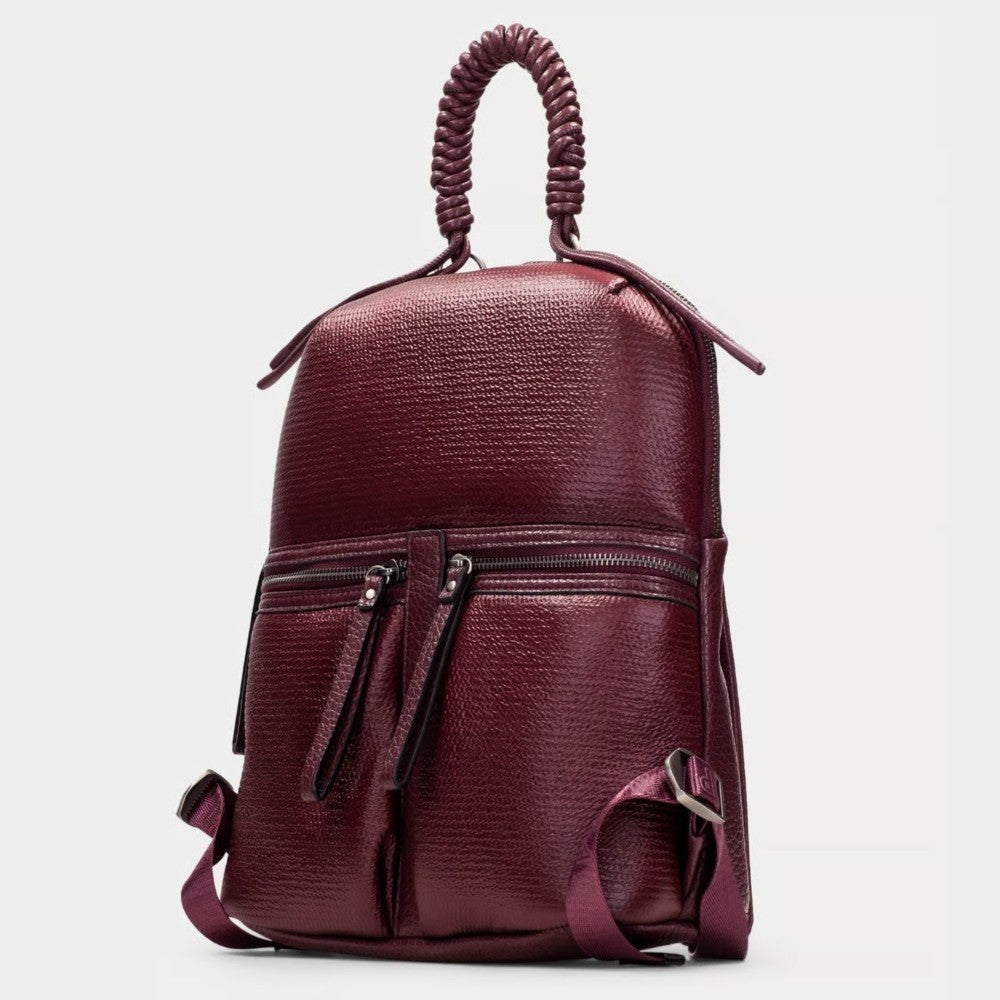 A Hispanitas textured metallic wine backpack with a braided top handle, gold-tone zippers, and matching  straps, shown against a light grey background.