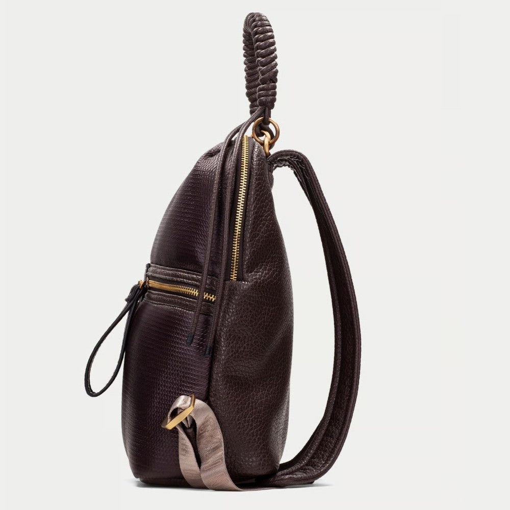 A Hispanitas dark brown textured  backpack with a braided top handle, gold-tone zippers, and grey  side accents, shown against a light grey background.