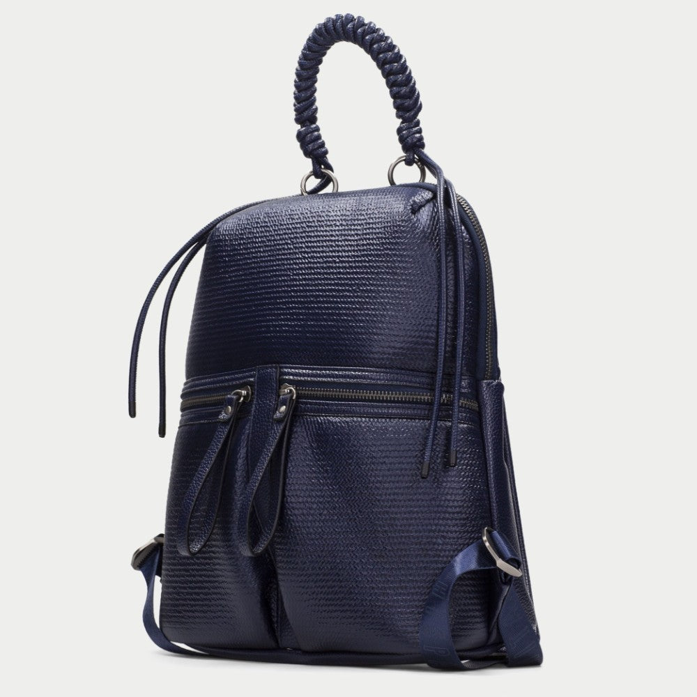 A Hispanitas navy blue textured backpack with a braided top handle, dual front zippered pockets, and a detachable shoulder strap, shown against a light grey background.
