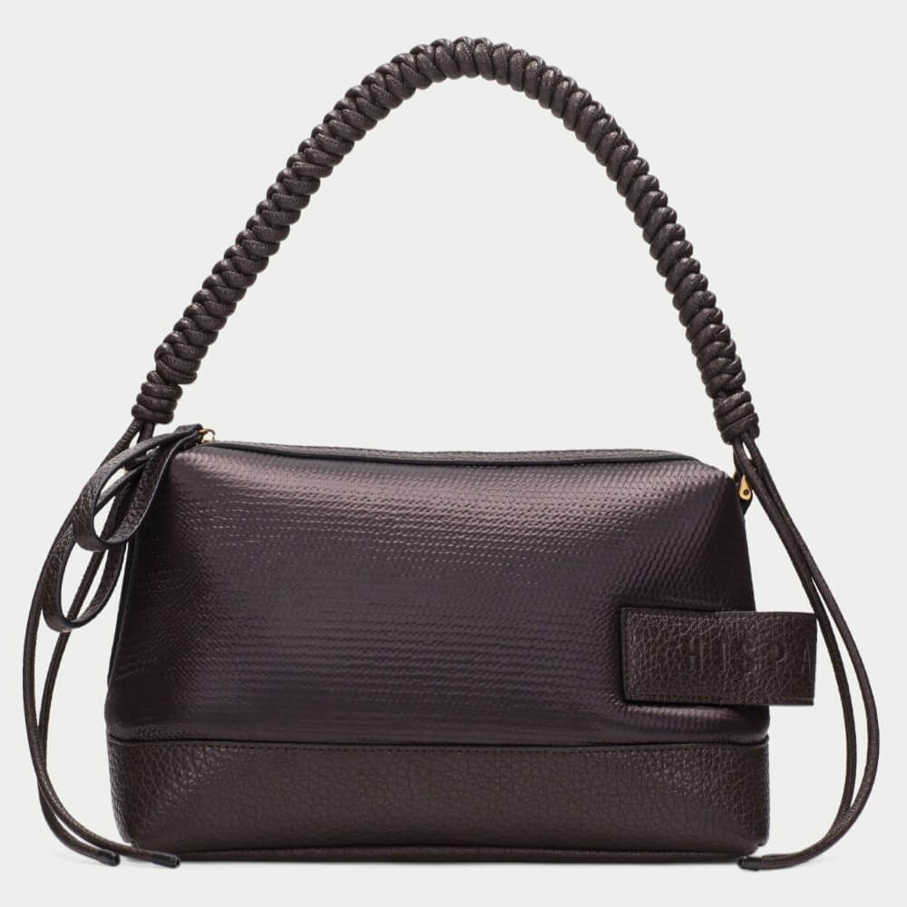 A Hispanitas dark brown textured handbag with a unique coiled shoulder strap and a small embossed brand patch on the front, set against a plain light grey background.