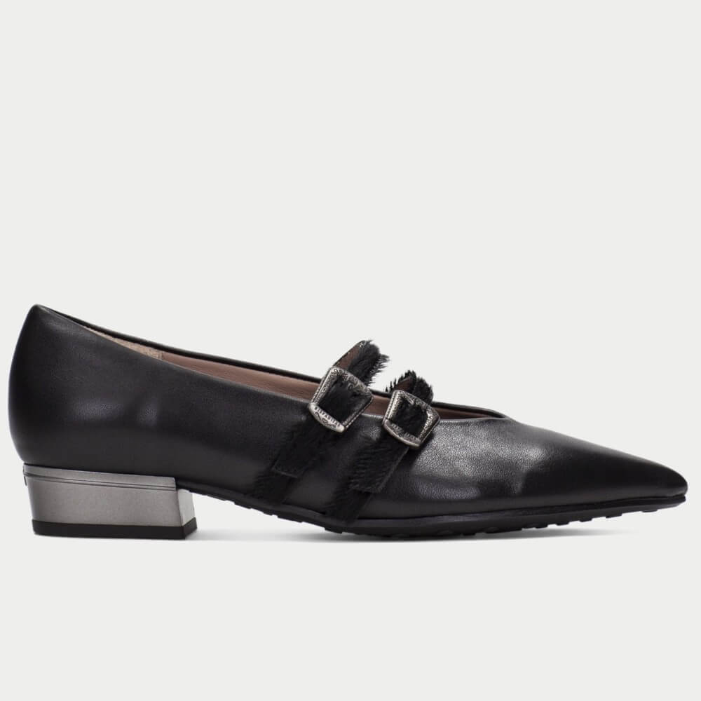 A Hispanitas black leather pointed-toe flat shoe with a low block heel and double buckle strap detail, shown in a side profile on a light gray background.
