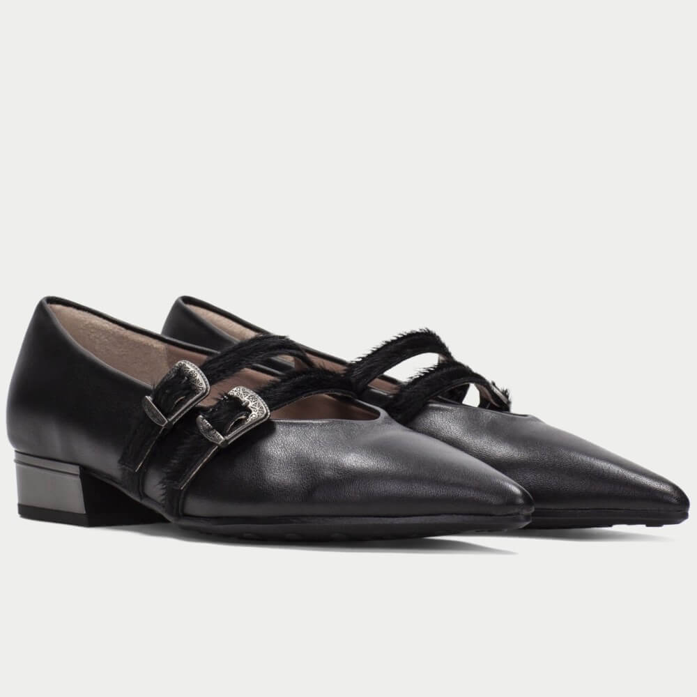 A pair of Hispanitas black leather pointed-toe Mary Jane flats with double buckle straps, shown against a light gray background.