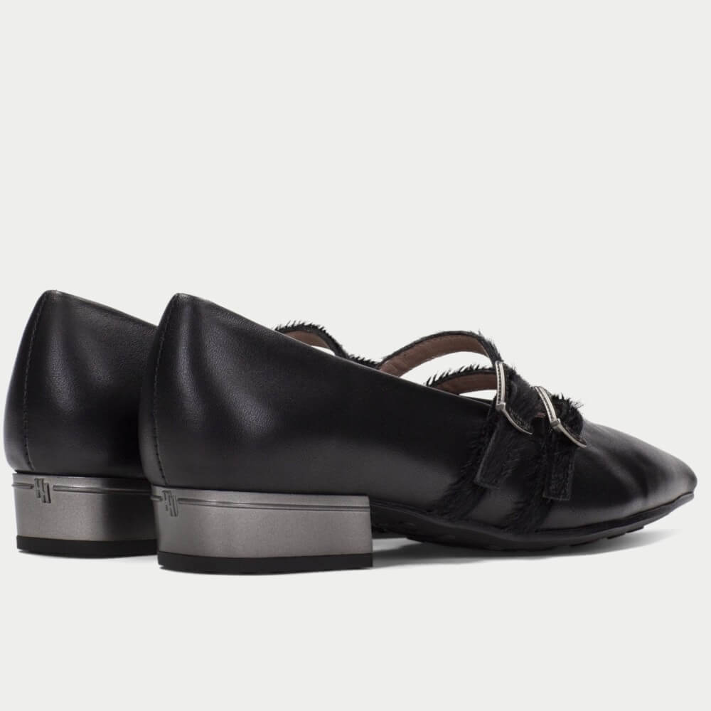 A pair of Hispanitas black leather pointed-toe Mary Jane flats with double buckle straps, shown against a light gray background.