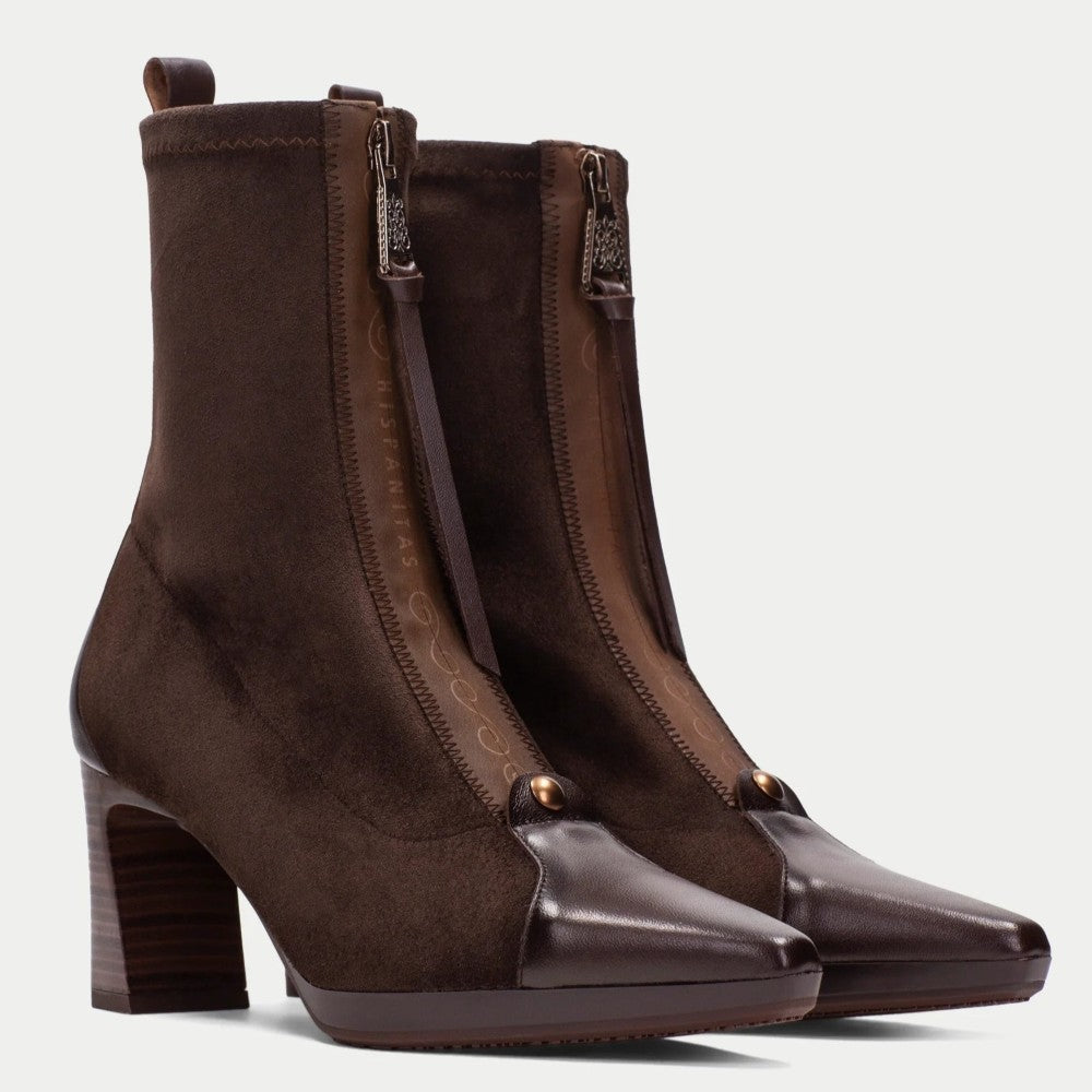 A pair of Hispanitas dark brown ankle boots with a mix of suede and smooth leather panels, featuring a block heel, pointed toe, and front zippers, shown against a light grey background.