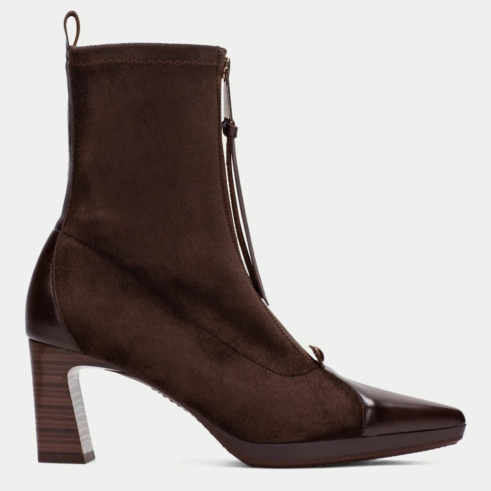 A Hispanitas dark brown ankle boot with a mix of suede and patent leather panels, featuring a block heel, pointed toe, and a front zipper with a tassel pull.