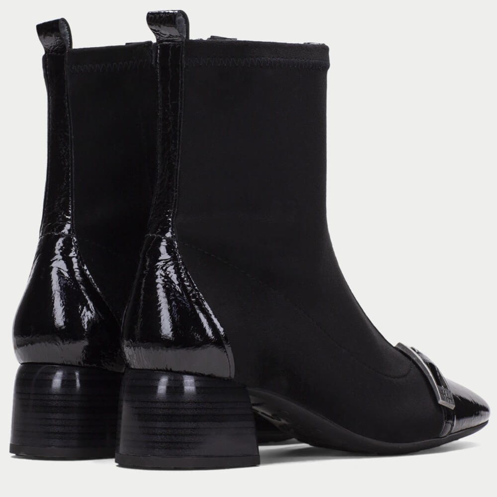 Hispanitas Black ankle boots with a mix of matte and glossy patent leather panels, a pointed toe, and a block heel, shown from a side-rear angle on a light gray background.