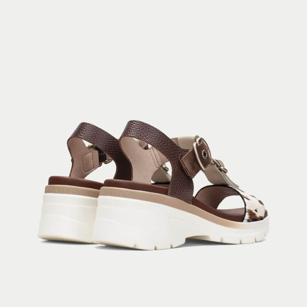 Brown sandals with white soles on a light gray background