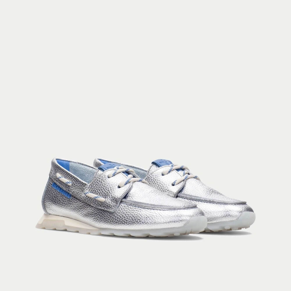 Silver sneakers with blue accents on a light gray background