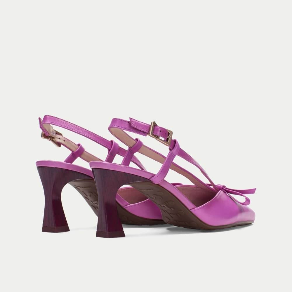 Pair of pink high-heeled shoes on a light gray background