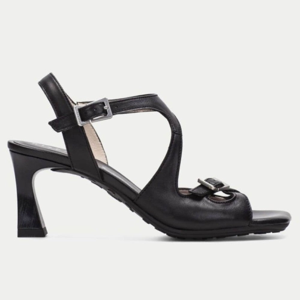 Black sandal with a high heel on a light gray background