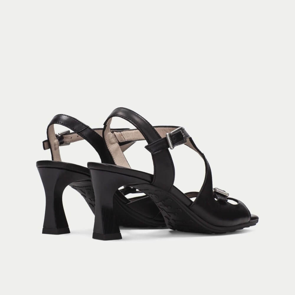 Black high-heeled sandals with a strap design on a light gray background