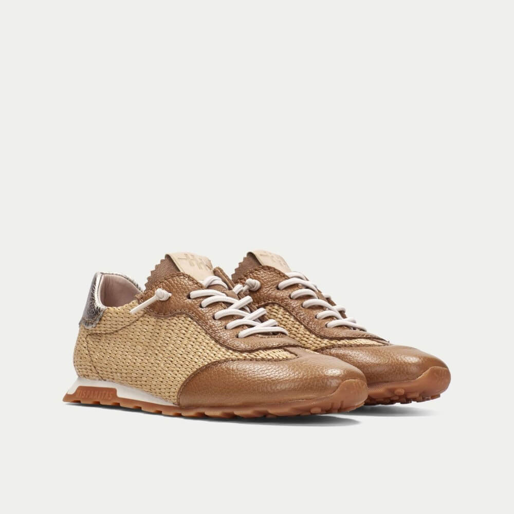 Pair of brown sneakers with white laces on a light gray background